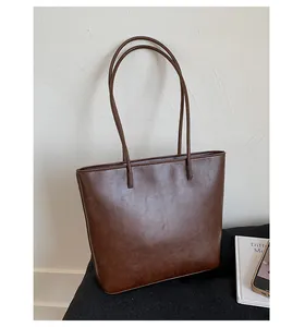 Large capacity brown leather tote bag for women in a minimalist lifestyle setting.