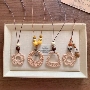Detailed view of various bohemian woven necklaces featuring wood beads and rattan pendants