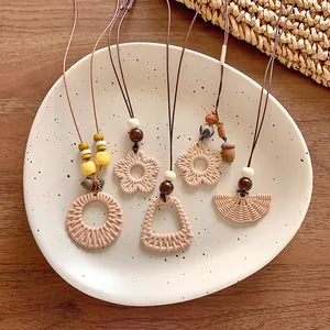 Detail view of Bohemian woven flower and geometric pendant necklaces for vacation