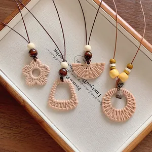 Detail view of bohemian woven necklaces with various geometric charms on a display
