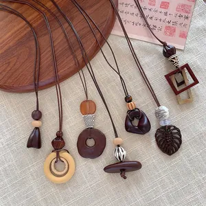 Collection of various brown wooden geometric necklaces on a textured fabric background