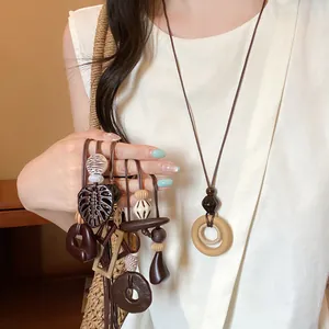 Detailed view of multiple geometric brown wooden pendant necklaces worn by a model