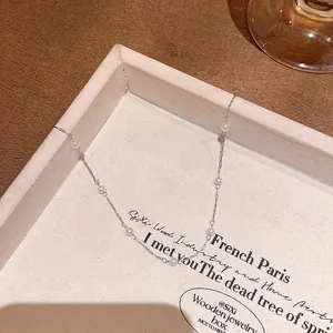 Elegant close-up view of a starry sky small pearl necklace resting in a cream jewelry tray