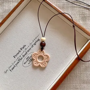 Bohemian woven flower pendant necklace with wooden beads for vacation beach style.
