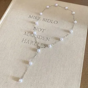 Elegant silver Y-shaped tassel necklace featuring multiple pearls in a station design