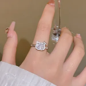 Nahaufnahme eines silbernen Katzenrings mit funkelnden Kristallen an einem Frauenfinger
