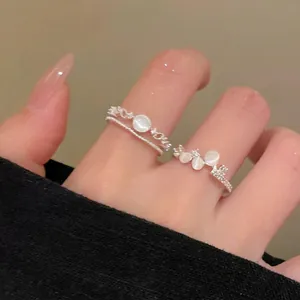 Close-up of elegant cat-eye stone rings layered on fingers with butterfly and round accents.