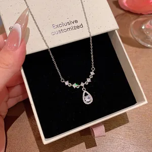 Detailed close-up of a teardrop zircon pendant necklace in an elegant gift box