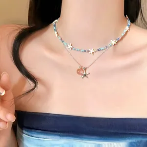 Detailed view of the layered starfish shell crystal beaded necklace on a model
