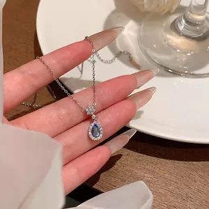 Macro detail of the sparkling blue teardrop pendant and zircon flower setting