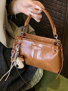 Elegante bruine vintage leren crossbodytas met handvat en puppy bedeltje