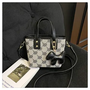 Close-up view of the trendy monogram bucket bag with a cute black puppy charm and strap