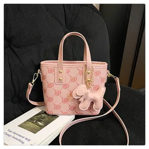 Chic pink monogram bucket bag featuring a stylish dog charm in a lifestyle setting