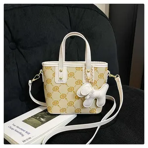 Elegant cream monogram bucket bag with a cute white dog charm and leather strap