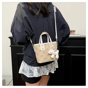 Elegant monogram bucket bag with white handles and balloon dog charm detail
