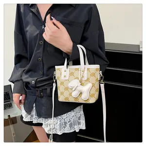 Trendy monogram bucket bag for women featuring a cute puppy charm and white strap