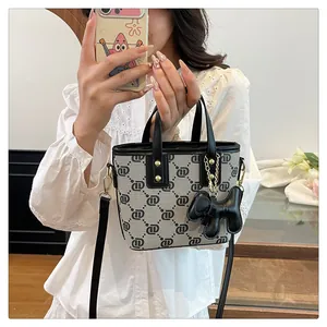 Elegant monogram bucket bag with black leather trim and a cute dog charm for women
