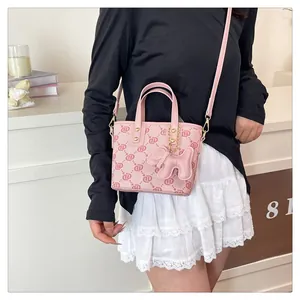 Detail view of pink monogram crossbody bucket bag with cute dog charm shown on model