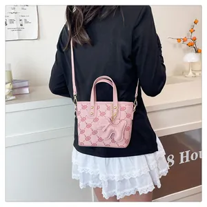 Stylish pink monogrammed small bucket bag shown as a crossbody on a female model.
