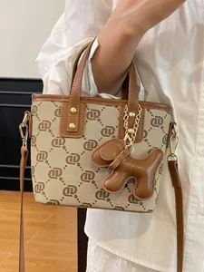 Elegant vintage monogram bucket handbag with brown leather trim and a cute dog charm