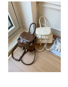 Detail view of stylish mini leather backpacks in brown and cream white colors