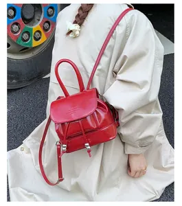 Model wearing a stylish red mini backpack for women in a street setting