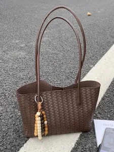 Stylish vintage dark brown woven leather tote bag with long handles and bead charm detail