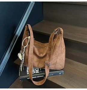 Vintage brown suede tote bag shown on a wooden staircase for a stylish daily commute look