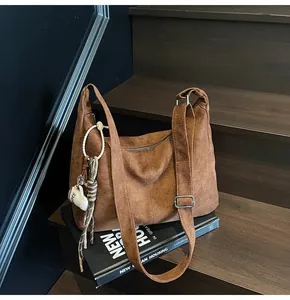 Detail view of a vintage brown suede tote bag resting on steps with urban prop