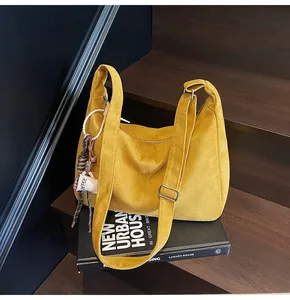 Close-up of yellow large suede hobo bag on stairs with urban lifestyle decor props