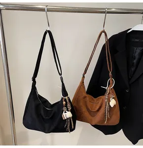Retro large suede hobo bags in black and brown hanging on a clothing rack