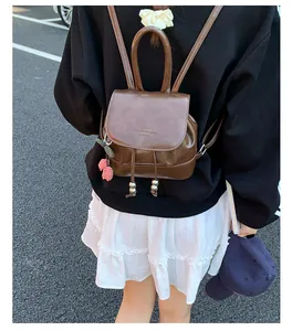 Stylish brown mini faux leather backpack shown in a trendy street style outdoor setting