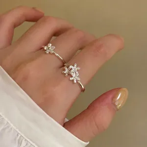 Close-up view of elegant flower zircon rings on hand with warm ambient lighting