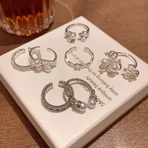 Detailed view of multiple French baroque pearl open rings on a white display box
