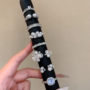 Elegant French Baroque style silver rings with pearls and crystals shown on black display