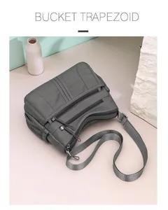High-angle view of a gray multi-pocket crossbody bag featuring an adjustable strap