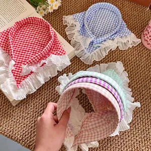 Detalle de cuellos de cuadros vichy con volantes en varios tonos pastel decorativos.