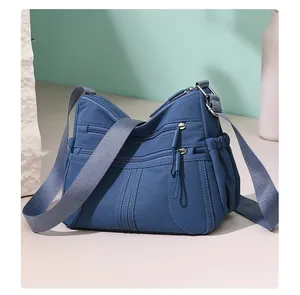 Detailed view of a stylish blue multi-pocket crossbody bag for women with smooth zippers