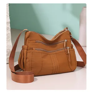 Close-up detail of a brown multi-pocket nylon crossbody bag designed for middle-aged women.