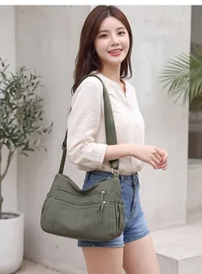 Fashionable green large capacity multi-pocket crossbody bag shown on model in daylight
