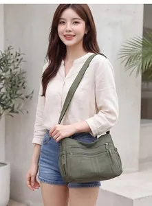 Olive green multi-pocket crossbody bag shown on a model in a casual outdoor setting