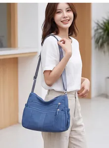 Lifestyle view of a versatile blue crossbody bag with multiple zippered pockets.
