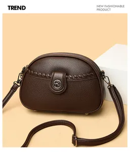 Detailed view of women's brown soft leather crossbody bag featuring a kangaroo metal logo
