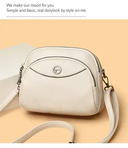 Detailed view of cream-colored three-layer crossbody bag with kangaroo metal logo