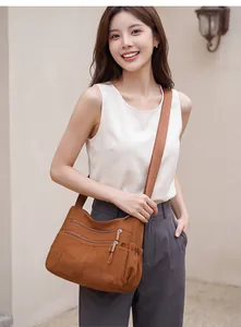 Young woman wearing a brown multi-pocket crossbody bag with an adjustable strap