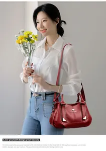 Elegant red soft leather handbag with three compartments shown on a professional Asian model