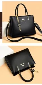 Detailed macro view of black pebbled leather handbag featuring elegant gold hardware