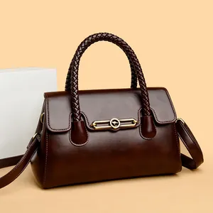 Elegant dark brown premium leather handbag with woven handles and decorative gold buckle.