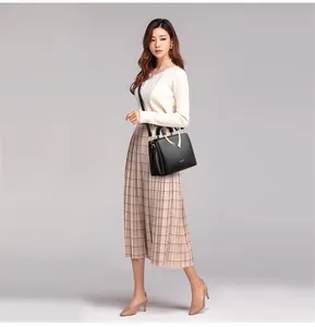 Elegante schwarze Handtasche aus Narbenleder, getragen von einem asiatischen Model