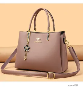 Close-up of a stylish mauve leather handbag with golden kangaroo logo and floral charm